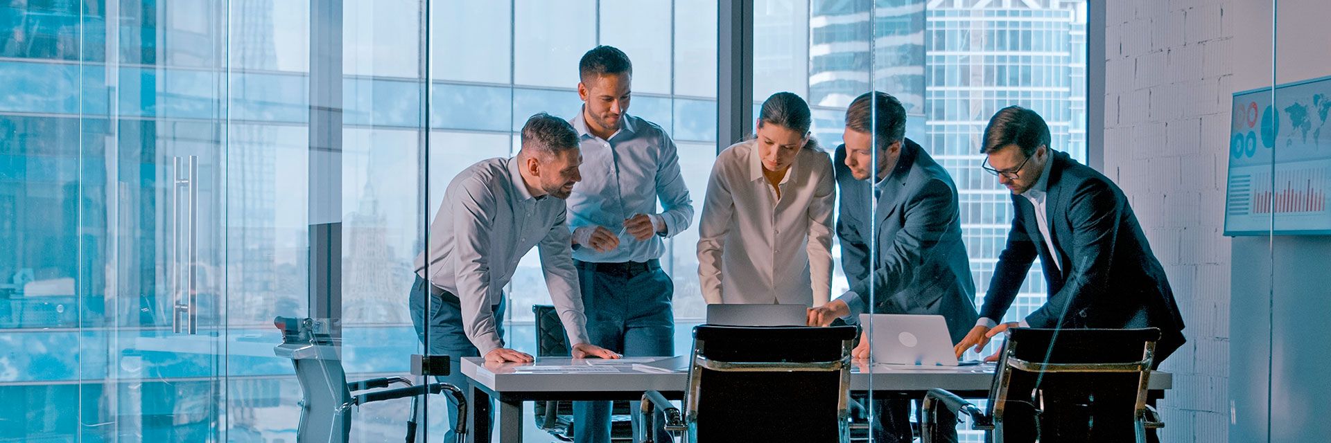 Business team collaborating around a conference table with documents and laptops in a modern office