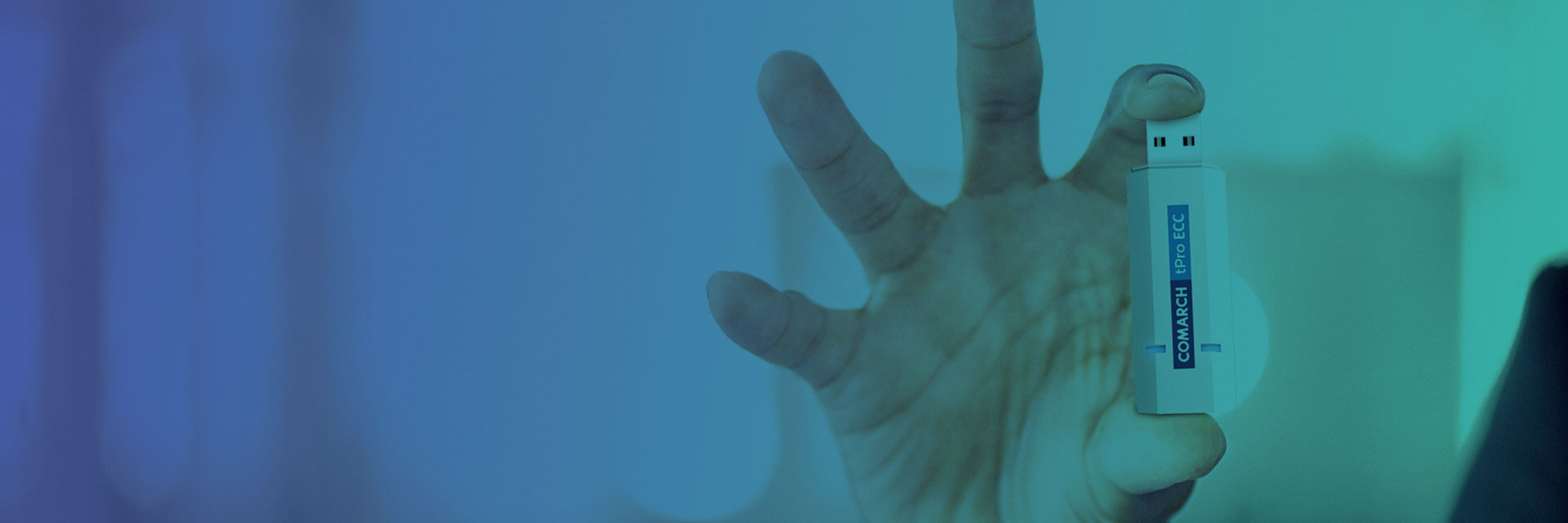 Hand holding a USB device labeled "COMARCH tPro ECC" against a blue gradient background.